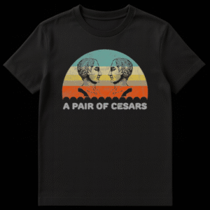 Two Julius Caesar busts facing each other with retro sunset background and text reading A PAIR OF CESARS on Black t-shirt