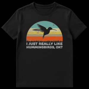 A black t-shirt design featuring a vintage distressed sunset in teal, yellow and orange stripes with a black hummingbird silhouette and text reading I Just Really Like Hummingbirds Ok on Black t-shirt