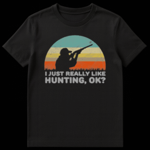 Black t-shirt with a vintage-style sunset graphic featuring teal, cream, and orange stripes. A black silhouette of a hunter with a rifle and tall grass is layered over it. Below, the text reads "I JUST REALLY LIKE HUNTING, OK?" in distressed light gray. on Black t-shirt