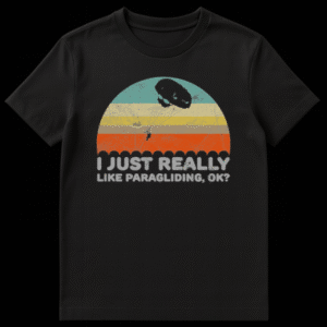 Vintage paragliding t-shirt with silhouette over distressed sunset and 'I JUST REALLY LIKE PARAGLIDING, OK?' text. on Black t-shirt