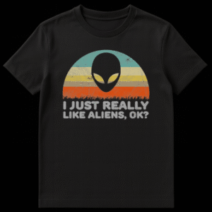 Retro-styled graphic t-shirt with a black alien head silhouette over vintage striped background, featuring text "I JUST REALLY LIKE ALIENS, OK?" on Black t-shirt