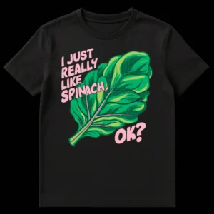 Vibrant black t-shirt featuring a retro-style green spinach leaf with pink veins and bold white text 'I JUST REALLY LIKE SPINACH, OK?' on Black t-shirt
