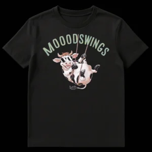 Cartoon cow with sunglasses swinging from 'MOODSWINGS' text on a black t-shirt on Black t-shirt